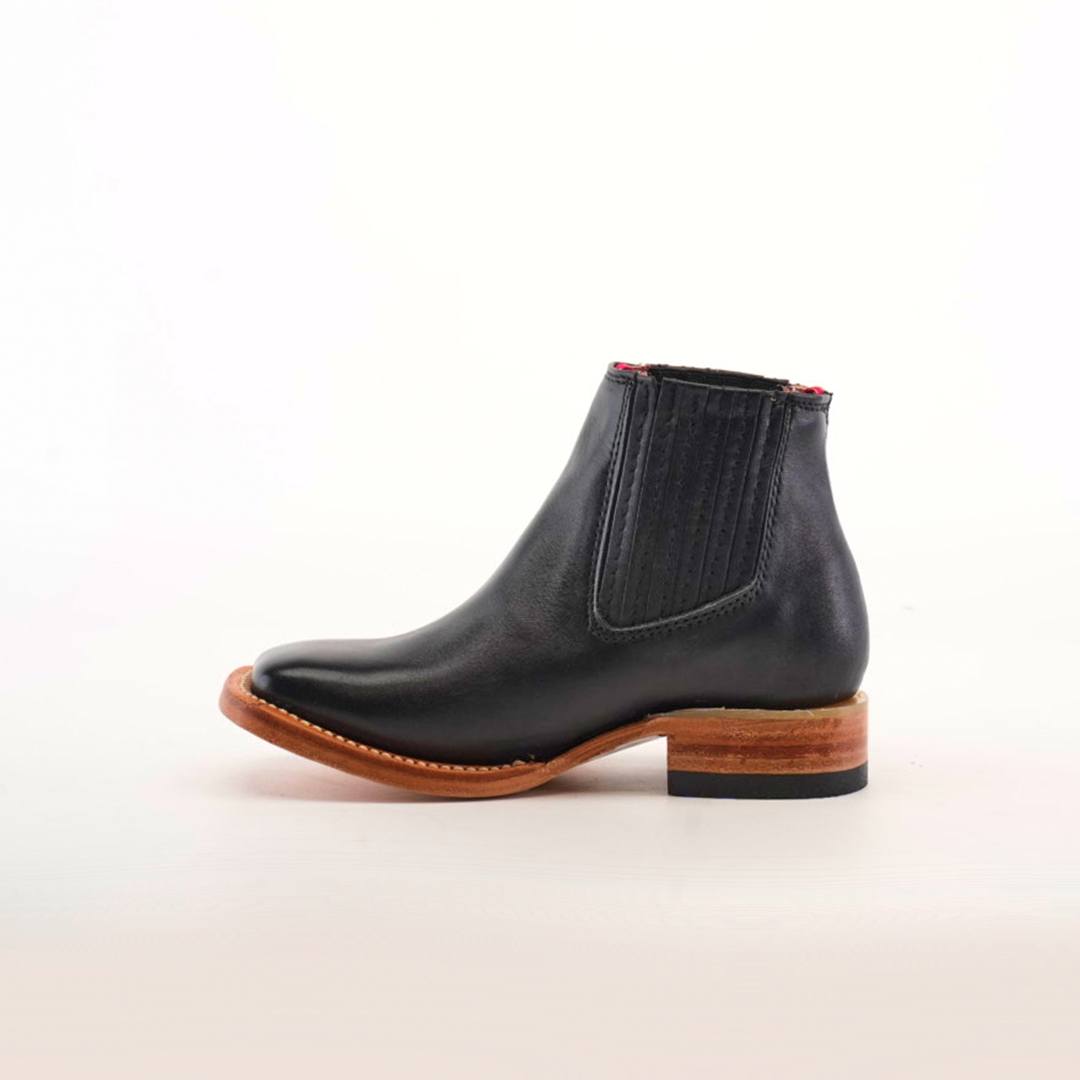 The Napa Black Square Toe Chelsea boot, crafted from genuine leather, features a wooden heel and dark elastic side panels, all showcased against a plain white background.