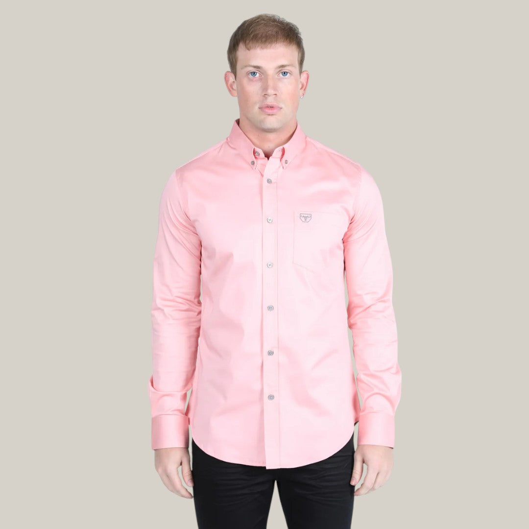 A person models the Men’s Single Pocket Logo Modern Fit Stretch Dress Shirt (Pink, CTL9826) against a gray backdrop. The shirts stretch fabric ensures comfort, and its styled with dark pants. They have short hair and look directly at the camera.