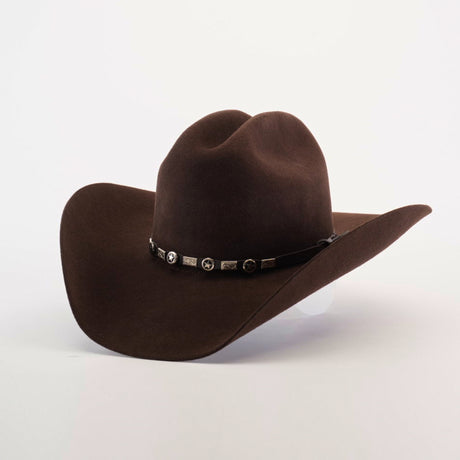 The 6X Country Brown is a dark brown felt cowboy hat crafted from premium sheep wool, featuring a wide brim and curved crown. It has a decorative black band with metallic conchos, embodying Western charm, set against a plain light background.