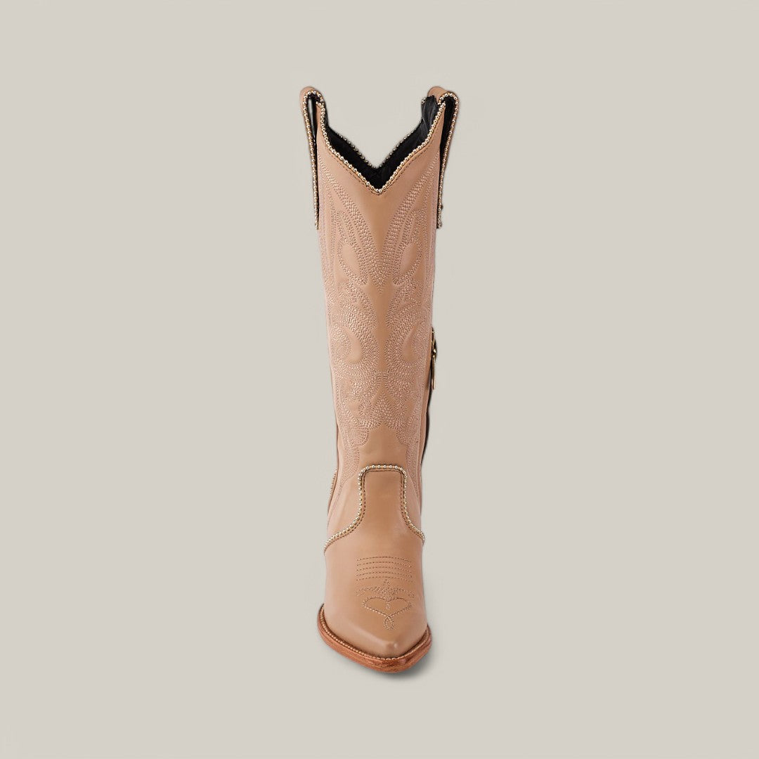 Front view of a single cream cowboy boot from the Linda Studs Tall Shaft Platinum Collection on a light background. Featuring intricate stitching, a pointed J toe, and a high shaft with decorative patterns, it embodies elegance.