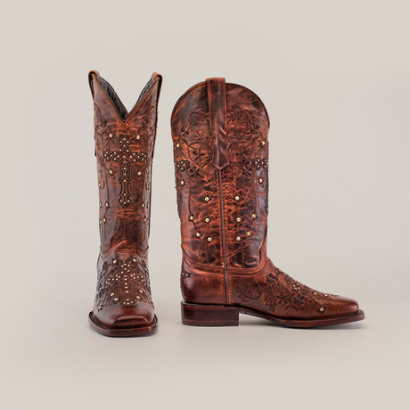 The Marga Cruz Brick Mid Shaft boots showcase a square toe design, crafted from premium leather with intricate floral patterns and studded details. The left boot highlights the front, while the right side view reveals their classic handcrafted elegance.