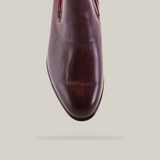 Top view of the Napa Wine - Round Toe, a shiny burgundy leather shoe demonstrating artesanía excepcional. It boasts a rounded toe and sleek finish on smooth texture, set against a plain white background.