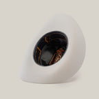 A 1000X Imperial White hat rests on its side against a plain background, revealing the dark brown and orange patterned interior with black lining, offering a glimpse of 100% genuine mink craftsmanship.