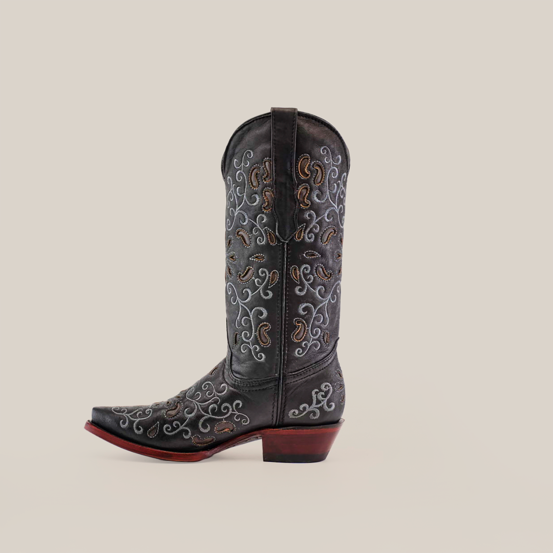 A handcrafted black cowboy boot, made of premium leather with intricate white, brown, and gray embroidery, sits on a plain white background. It features a pointed toe and a brown wooden heel reminiscent of the Alessandria Black - Mid Shaft - Snip Toe boots.