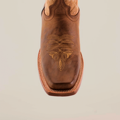 Experience luxury with the Western Stitch Camel boot, featuring a narrow square toe. Crafted from premium leather, it boasts intricate yellow embroidery, a decorative swirl pattern on the top, and contrast stitching along the sole for an eye-catching finish