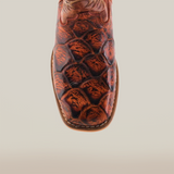 Close-up of the Pirarucu Bass Print Cogñac Square Toe cowboy boot, featuring premium reddish-brown leather with a unique Pirarucu bass print. The square toe design and visible stitching reflect expert craftsmanship on a simple light backdrop.