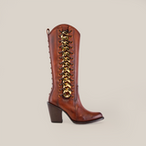 The Francia Rings Tall Shaft Tan - J Toe boots, part of the Platinum Collection, are brown leather with a chunky heel and premium finish. They feature a golden chain lace-up detail on the side and are elegantly displayed against a plain white background.