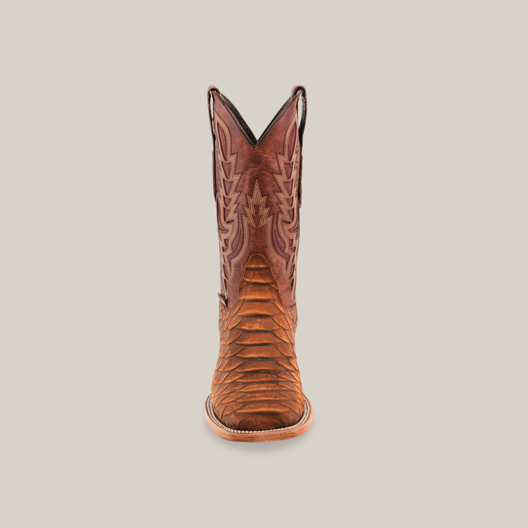 The Jumbo Python Print Cogñac cowboy boot in premium cowhide leather features intricate shaft stitching, a square toe, and a wooden sole, elegantly set against a plain white background.