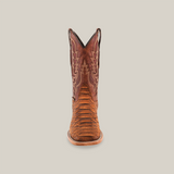 The Jumbo Python Print Cogñac cowboy boot in premium cowhide leather features intricate shaft stitching, a square toe, and a wooden sole, elegantly set against a plain white background.