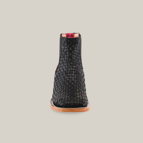 Front view of the Basket weave Black Square Toe ankle boot, featuring a woven black design with a tan sole and a finely textured basket weave pattern. The stylish boot is set against a plain, light-colored background.