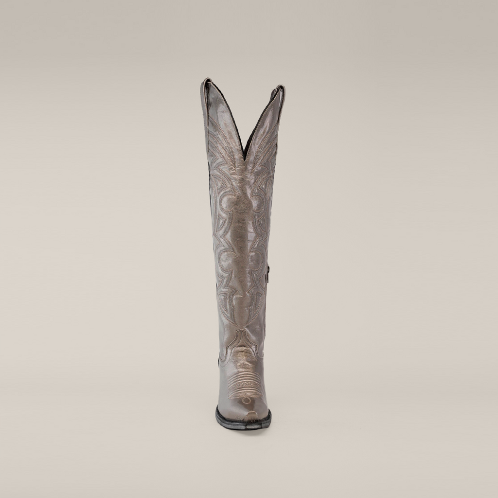 The Taylor Mercury cowboy boot features a tall silver shaft with intricate stitching, a snip toe, and a durable leather sole, all set against a plain white background.