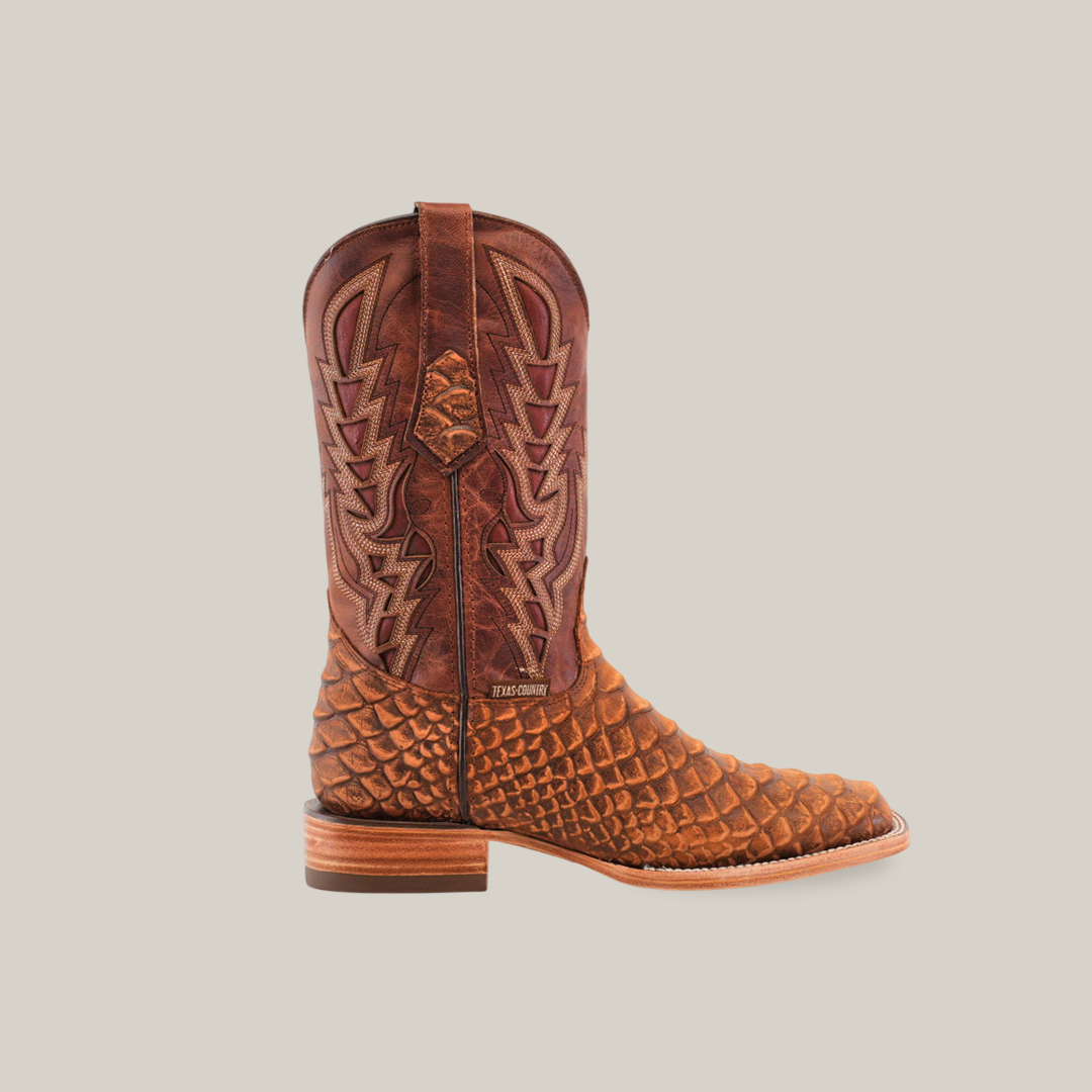 A single Jumbo Python Print Cogñac - Square Toe cowboy boot, in brown with an intricate stitched design, stands against a white background. It features a square toe, thick heel, and side pull straps, crafted from premium cowhide leather for both durability and style.