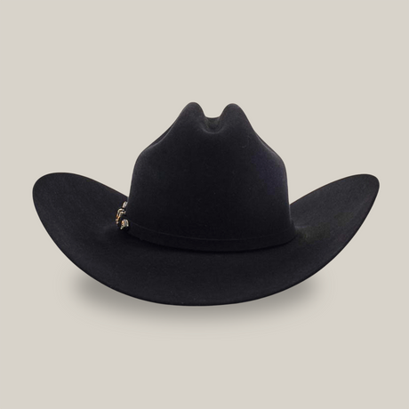 The 6X Real Black is a black fur felt cowboy hat with a wide brim, a subtle crease on the crown, and a decorative band, evoking iconic Western headwear.