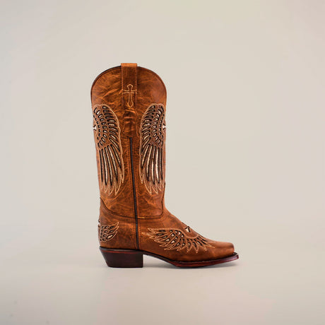 The Texas Cross Glitterbomb Camel boot, featuring a narrow square toe and mid shaft, showcases intricate embroidered wing designs with chic glitter details on a light background.