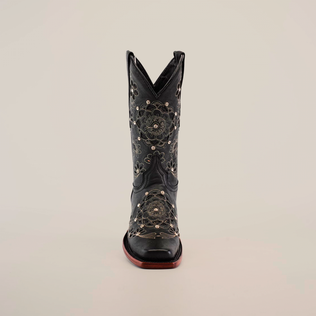 The Mayan Flower Crystals Black boot, featuring a handcrafted design with intricate floral embroidery and a sturdy brown sole, stands upright against a plain white background.