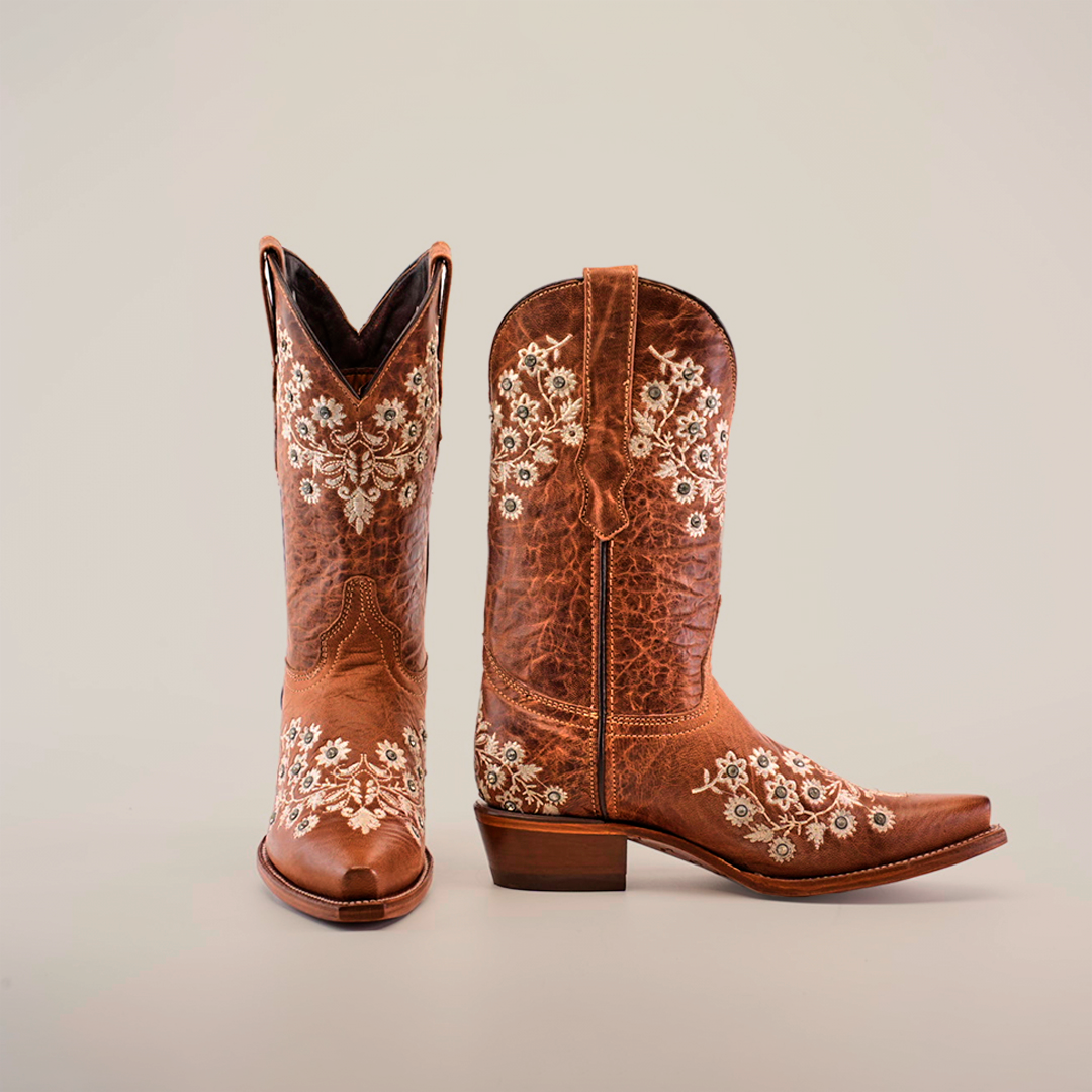 A pair of Abril Crystals - Mid Shaft - Snip Toe boots in rich brown with white floral embroidery is set against a white background. One boot stands upright, the other tilted, highlighting its western style and elegant side details.