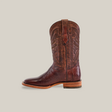 The Exotic Lizard - Brown - Square Toe boot, crafted from genuine lizard leather, features intricate stitching and a patterned shaft. It boasts a leather texture, a wooden sole, and a stylish square toe design against a plain light background.