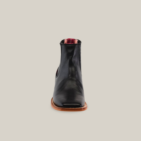 The handcrafted Napa Black Square Toe ankle boot features black leather with a smooth finish, red interior lining, and visible stitching on the wooden sole, bringing elegance to any cowboy scene.