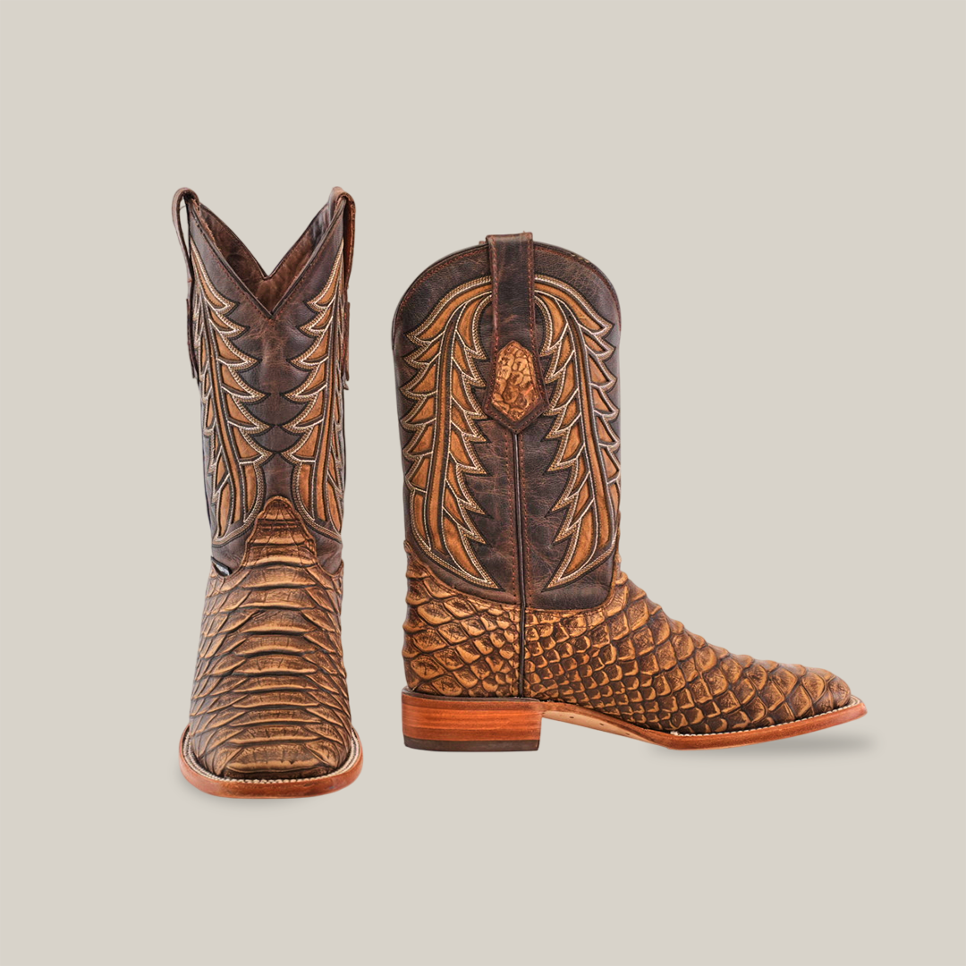 The Jumbo Python Print Cappuccino - Square Toe boots are handcrafted from premium cowhide leather, showcasing intricate stitching and a textured python-print appearance. One boot stands upright while the other is slightly angled.