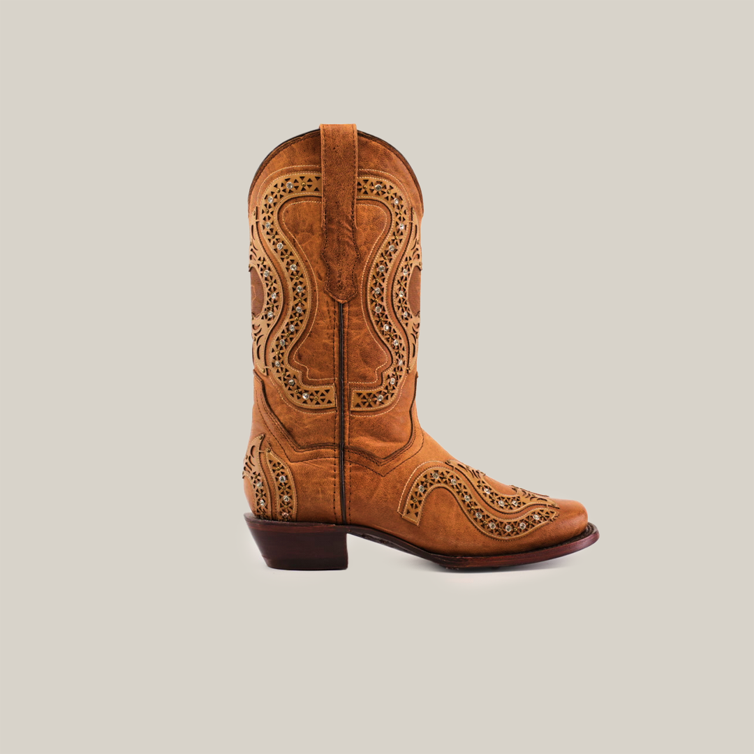 The Love Crystals Honey cowboy boot offers a premium leather design with intricate cutout patterns and a low heel, crafted by hand. Set against a white background, this brown western-style boot exemplifies elegance and quality with its short shaft and narrow square toe.