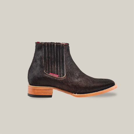 The Cowhide Hair Black Square Toe boot is a handcrafted black leather Chelsea style with a textured finish and wooden sole. Made from premium cowhide leather, it features elastic side panels for easy wear, blending modern style with timeless Western elegance.