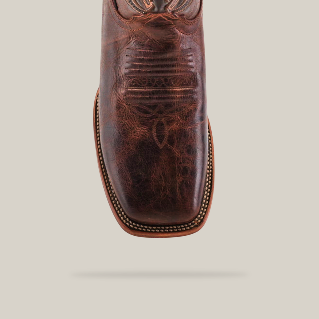 The Rustic Brown - Square Toe cowboy boot, crafted from cowhide leather, displays intricate stitching and a textured finish. It elegantly features a square toe design and double-stitched welt against a plain white background.