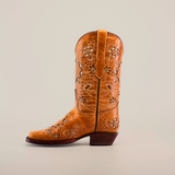 The tan Mayan Flower Crystals Orix cowboy boot, with floral cutouts and stitching, stands upright on a white background. Handcrafted by artisans, this short shaft boot has a medium heel and intricate details for rustic, stylish charm.