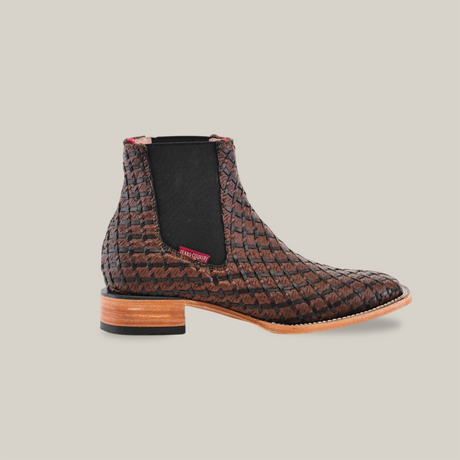 The Basket Weave BlackBrown Square Toe is a brown woven leather ankle boot with a unique basket weave pattern, featuring a small red tag, black elastic panel, light brown wooden heel, and sleek pointed toe design on a white background.