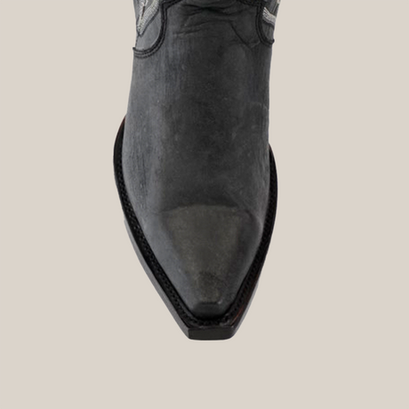 Close-up of the Tania Matte Black - Tall Shaft - Snip Toe Boot viewed from above, showcasing its pointed toe and detailed stitching on the sole. The boot is positioned vertically against a plain white background.