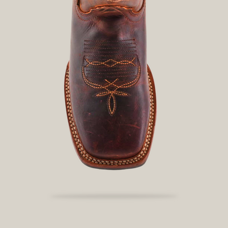 The Azkar Moka boot, showcased against a beige background, features a brown square toe crafted from premium cowhide leather with intricate vamp stitching and a textured welt pattern, all highlighted by its slip-resistant sole for classic Western style.