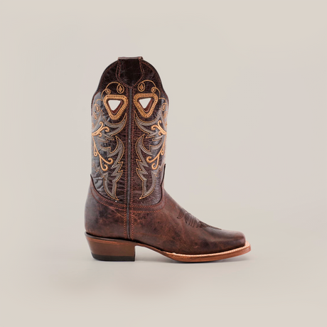 The Western Stitch Tabaco boot features a single brown cowboy design with top-quality leather, detailed yellow and beige embroidery swirls, diamond cut-outs, a narrow square toe, and a medium-height heel set against a plain white background.