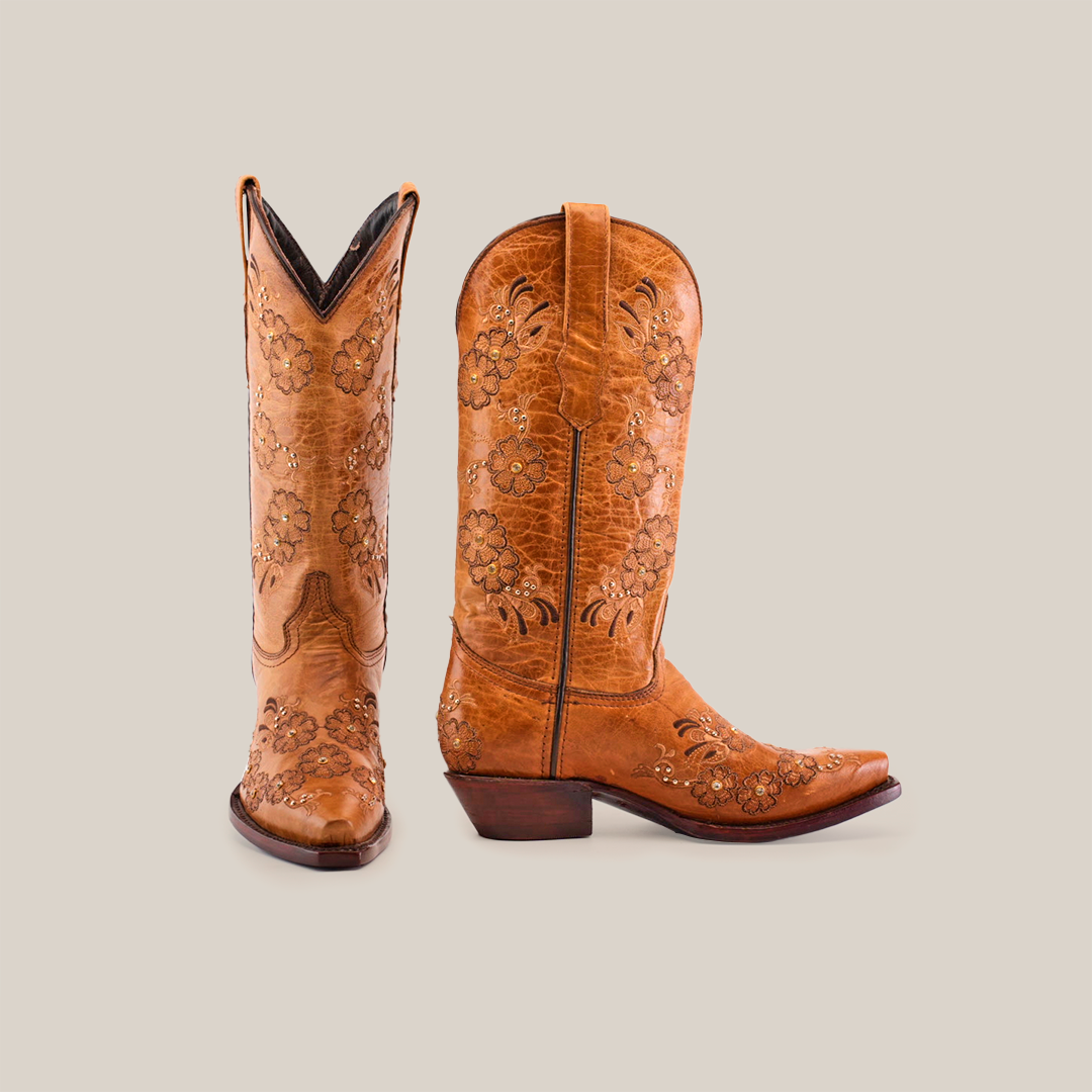 A pair of Florilandia Orix mid shaft brown leather cowboy boots with intricate floral embroidery appear on a white backdrop. One boot is upright, and the other, highlighting its snip toe design, is angled slightly.