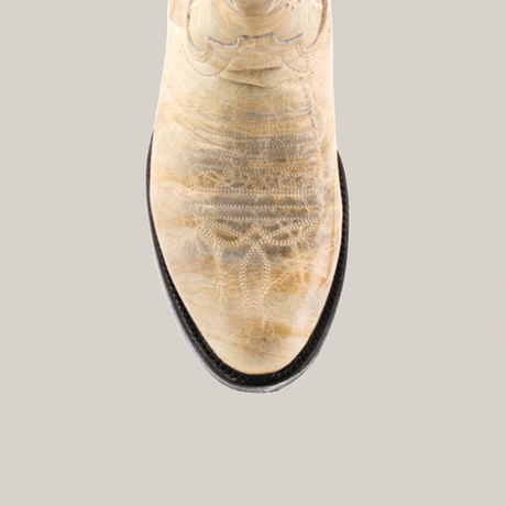 A top view image shows a Cowhide Hortus Rustic White cowboy boot made from cowhide leather, with intricate stitching, a rounded toe, and a dark brown sole, set against a white background.