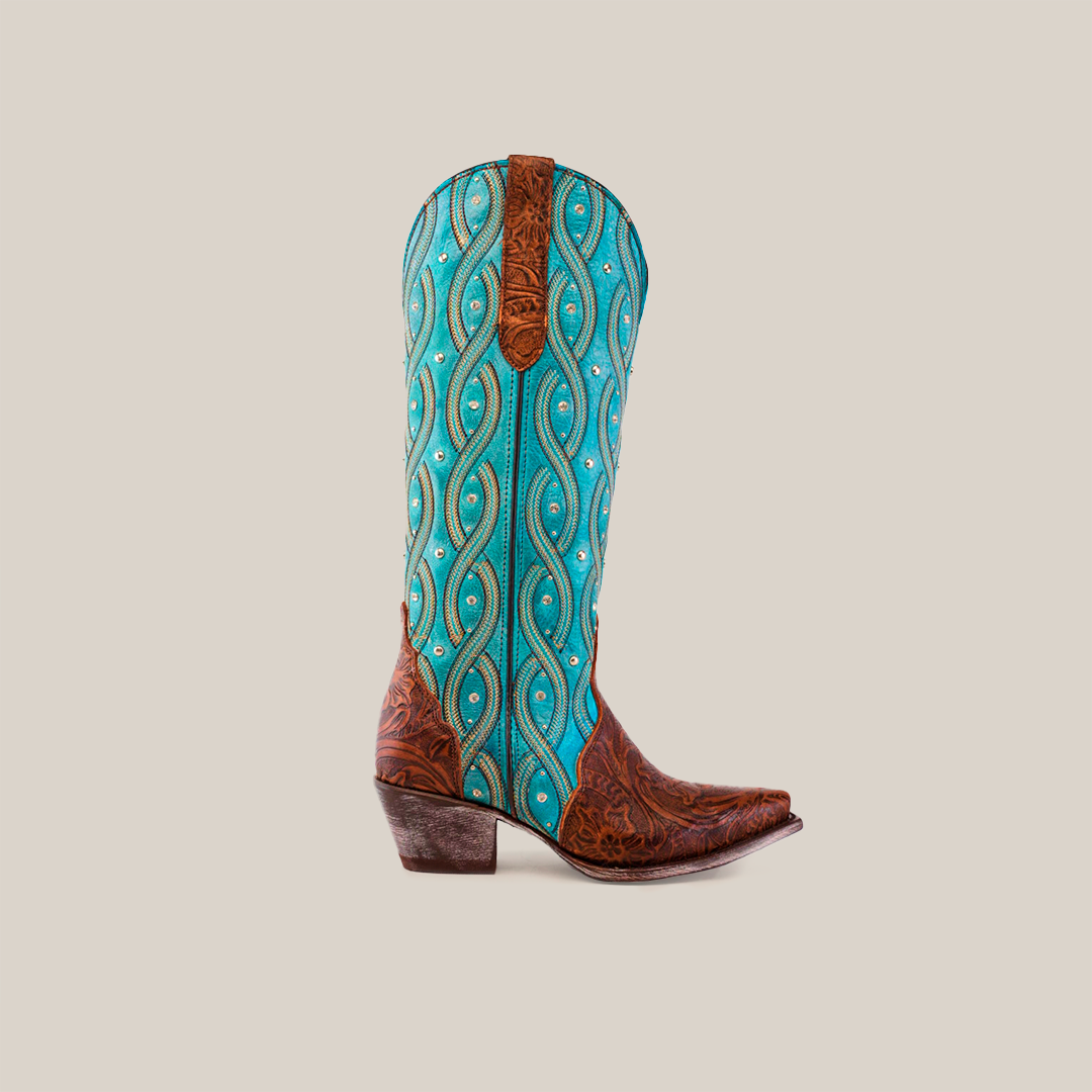 A cowboy boot with a snip toe and low heel exudes Western elegance. The turquoise shaft boasts swirling patterns and decorative studs, while the brown foot features intricate floral tooling reminiscent of Premier Tabaco Handtooled Flowers - Tall Shaft - Snip Toe boots.