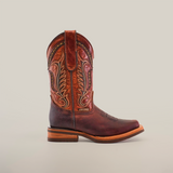 An Azkar Moka Slip Resistant Sole Rodeo Toe boot in brown leather, showcasing intricate stitching, is set against a plain white background. With a rounded toe and wooden heel, this stylish and functional boot is perfect for any occasion needing slip-resistant soles.