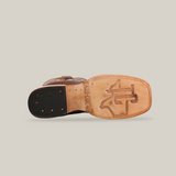 The image highlights the classic charm of the Dessert Camel - Square Toe cowboy boot. Its tan leather sole features an embossed logo, and visible nails on the black heel. Crafted from premium cowhide, this boot is set against a plain white background.