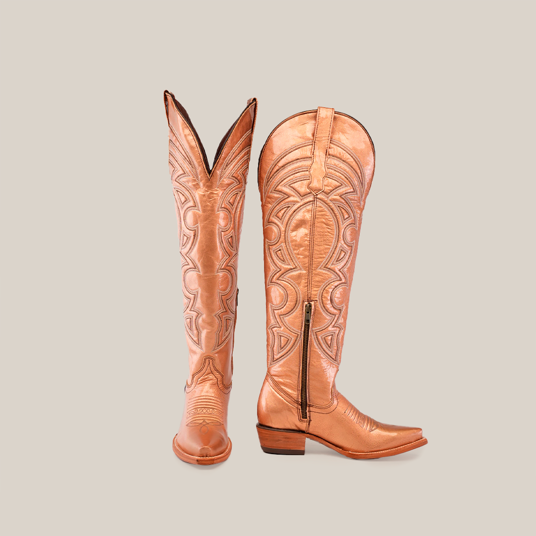 A pair of Taylor Rose Gold cowboy boots, tall and light brown leather with intricate embossed designs, featuring a snip toe and low heel. The left boot stands upright; the right is angled to show its side.