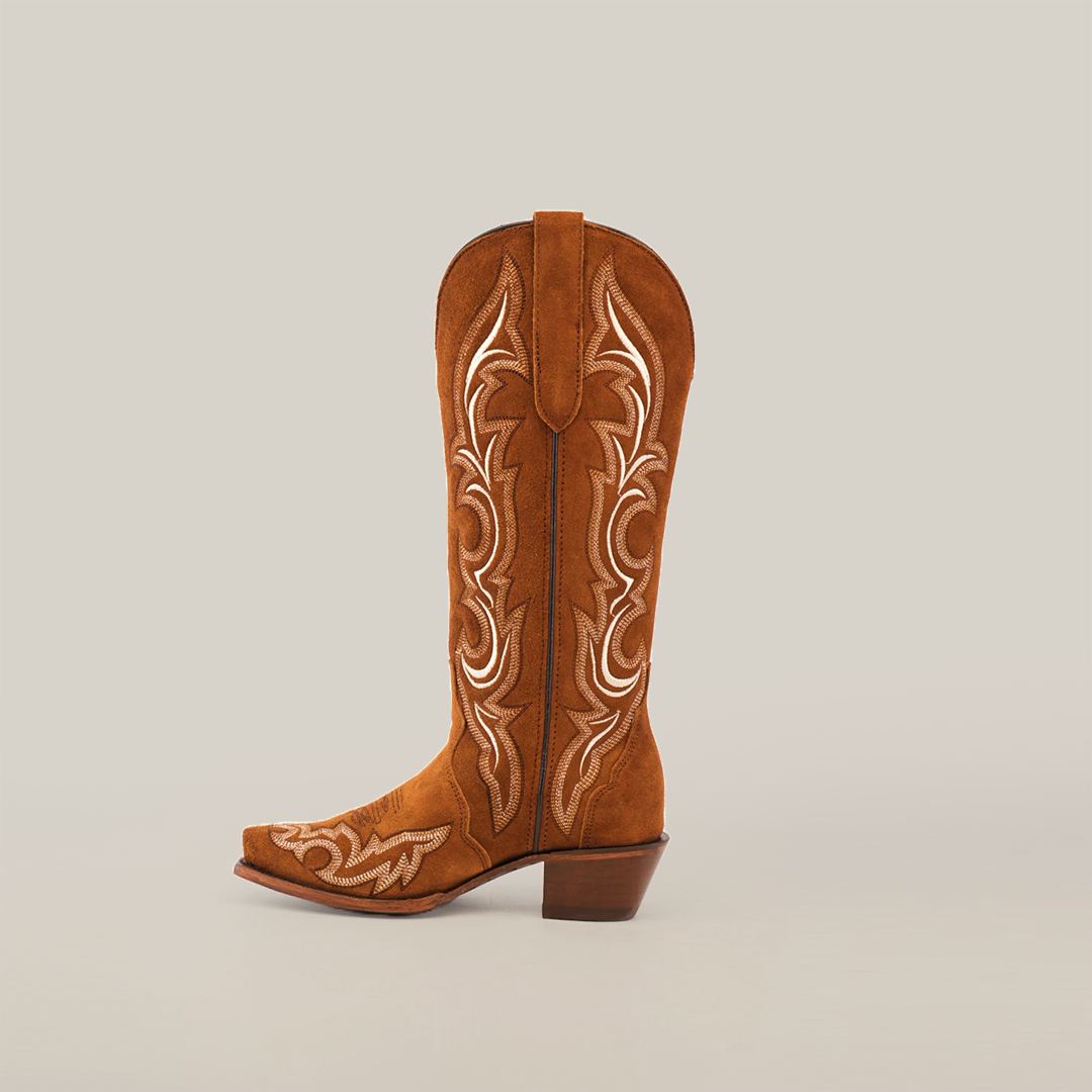 The Amara Tabaco Suede - Tall Shaft - Snip Toe cowboy boot is a luxurious piece with intricate white embroidery on the shaft, featuring a snip toe, stacked heel, and pull straps. This elegant womens boot stands against a plain white background.