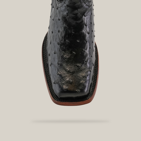 Close-up of the Exotic Ostrich - Black boot with a Rodeo Toe, crafted from genuine ostrich leather, highlighting its characteristic textured bumps against a simple background.