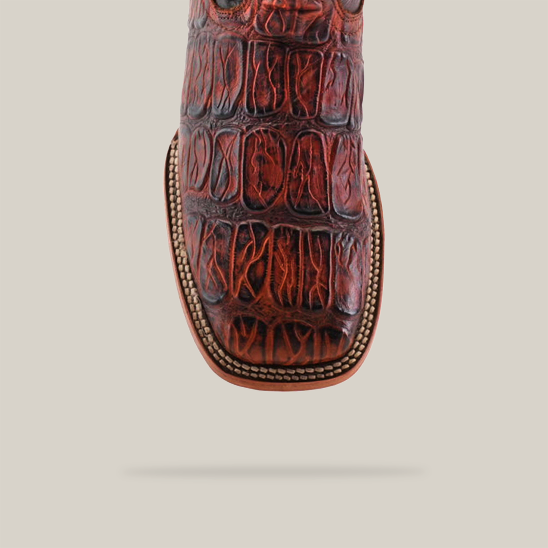 Close-up of the Gator Print Cogñac - Square Toe boot, showcasing rich brown premium cowhide with a Gator Print Cognac pattern. It features intricate stitching on the top edge and a light-colored sole with decorative trim.