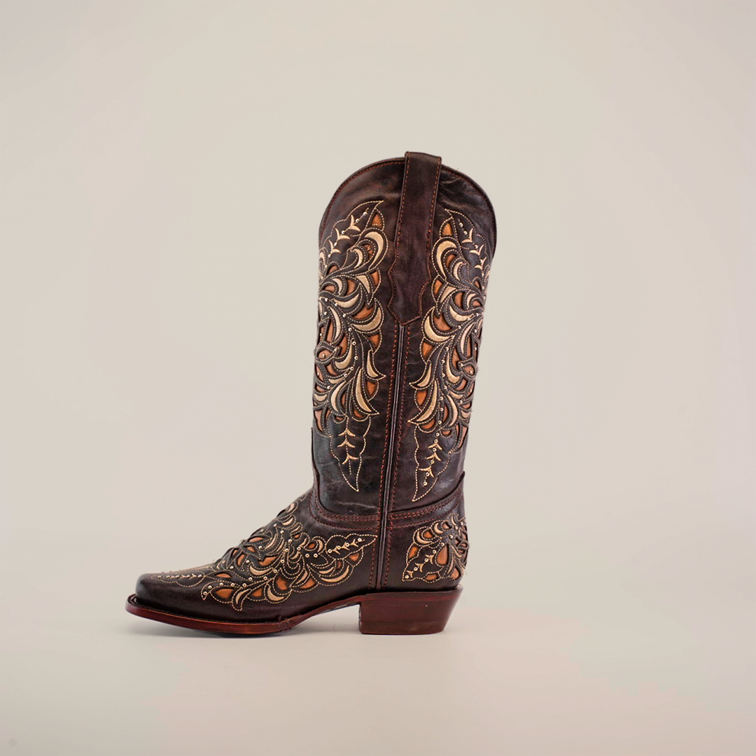 The Kiara Crystals Chocolate boot, a premium leather womens cowboy boot with intricate light brown and gold embroidery in swirling floral patterns, features a low heel and narrow square toe. It stands upright against a plain white background.