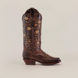 Explore the Dariela Brown Mid Shaft boots with a narrow square toe: an artisanal cowboy boot crafted from handcrafted leather, adorned with intricate yellow floral embroidery on the shaft.