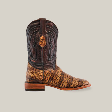 The Gator Print Orix - Square Toe boot is showcased against a white background, featuring a dark upper with ornate stitching, a lighter textured foot and heel, and crafted from cowhide leather. A wooden sole completes its traditional style.