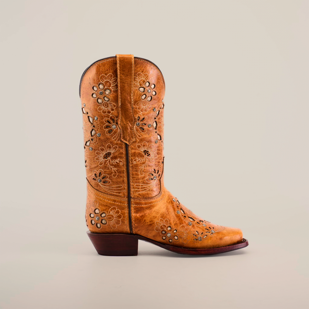 The Mayan Flower Crystals Orix boot, with a narrow square toe and intricate floral cutout patterns, features decorative stitching on a tan short shaft. Handcrafted by artisans with a low heel, this boot is beautifully displayed on a white background.