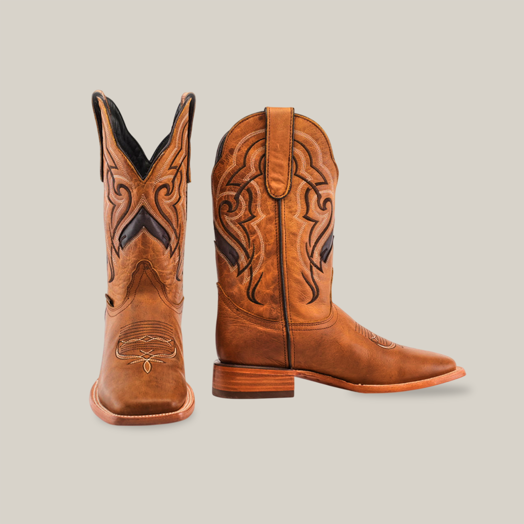 A pair of Wild Mustard - Square Toe cowboy boots in brown, featuring intricate stitching and crafted from premium cowhide. Displayed against a white background, one boot is upright while the other is slightly angled to reveal the elegant design and genuine leather sole.