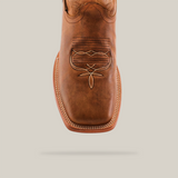 A close-up of the Wild Mustard - Square Toe cowboy boot highlights its premium cowhide and intricate stitching on the toe, featuring light-colored stitching around its genuine leather sole, all against a plain white background.